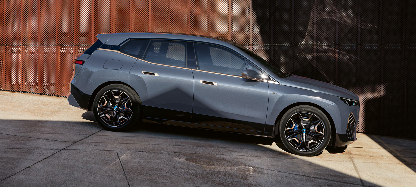 BMW iX M60 i20 2022 sähköinen SUV sähköauto metalliväri Oxide Grey sivukuva pysäköitynä