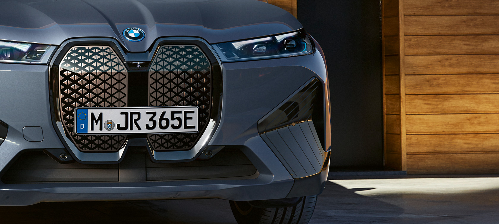 BMW iX M60 i20 2022 sähköinen SUV sähköauto metalliväri Oxide Grey lähikuva keulasta kuvassa pystysuuntainen BMW -jäähdyttimen säleikkö