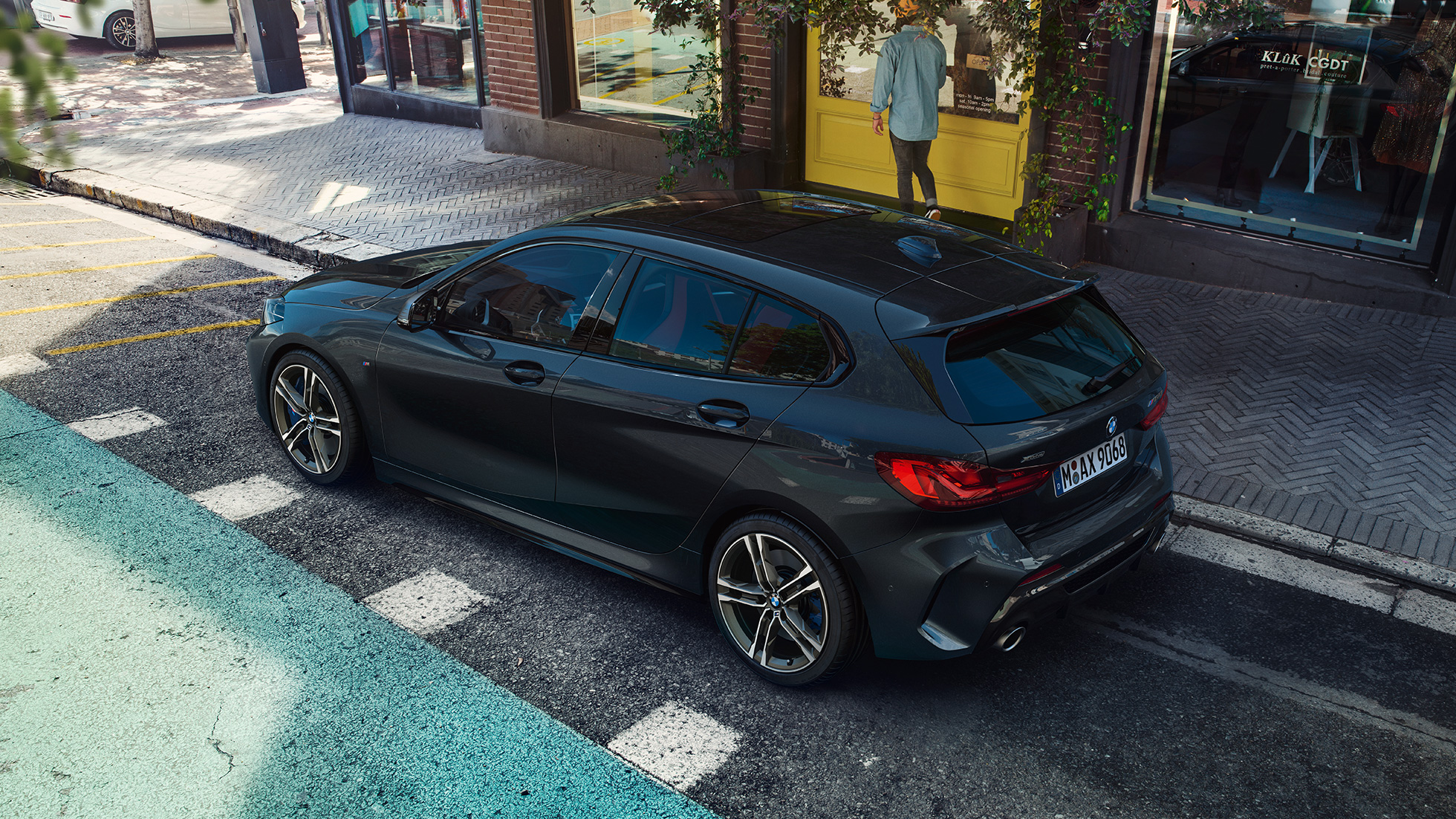 BMW M135i xDrive pysäköitynä. MW M135i xDrive i, metalliväri Sapphire Black, pysäköity sivunäkymä lintuperspektiivistä.