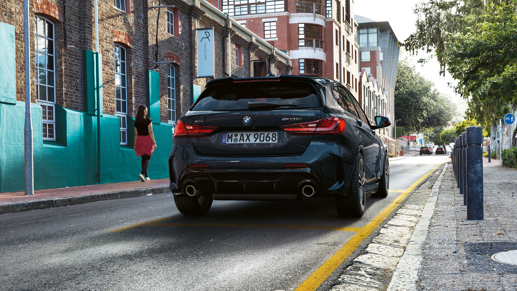 BMW M135i xDrive, peräosa. BMW M135i xDrive, metalliväri Sapphire Black, näkymä pysäköidyn auton perästä.