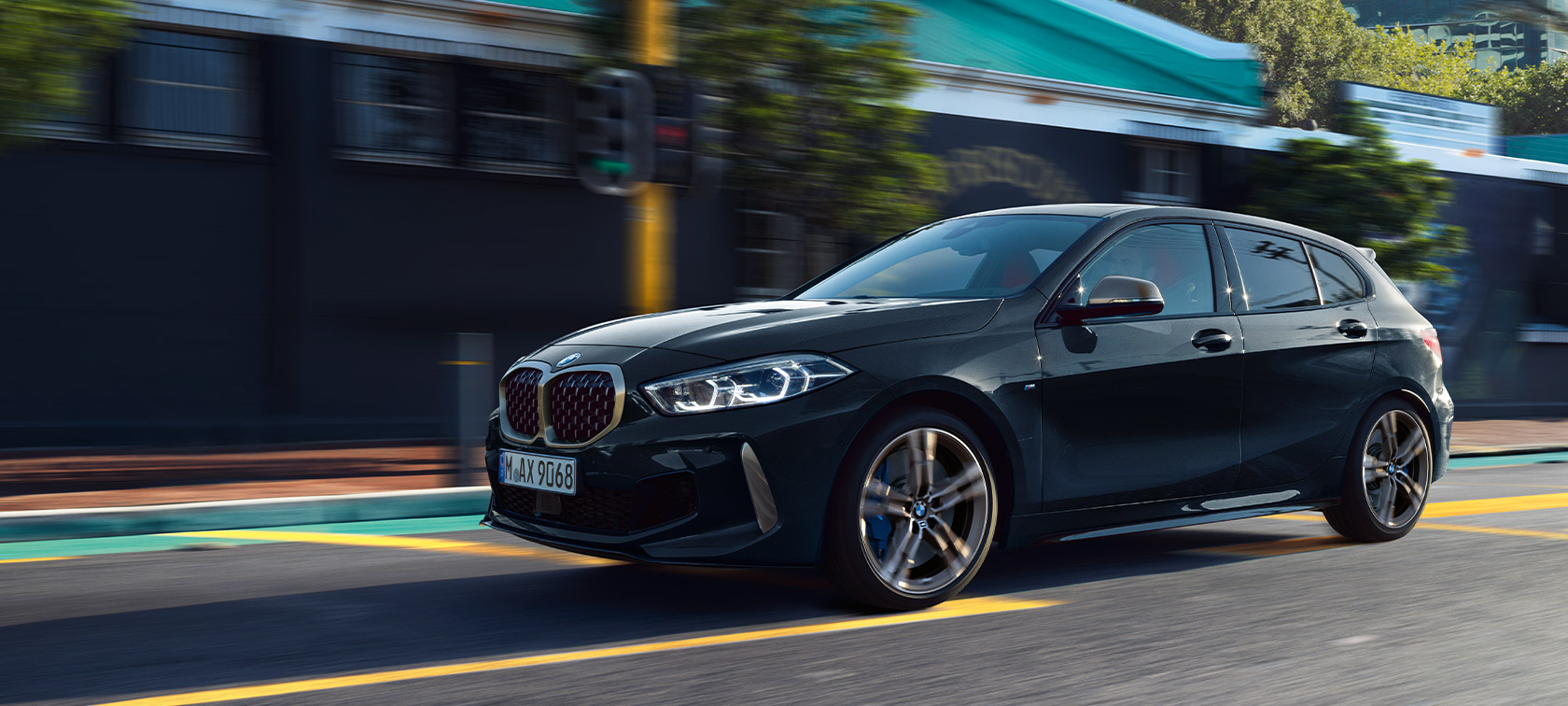 BMW 1-sarjan M135i xDrive (F40), metalliv&auml;rill&auml; Black Sapphire, liikkeell&auml; oleva auto kaupunkiymp&auml;rist&ouml;ss&auml;