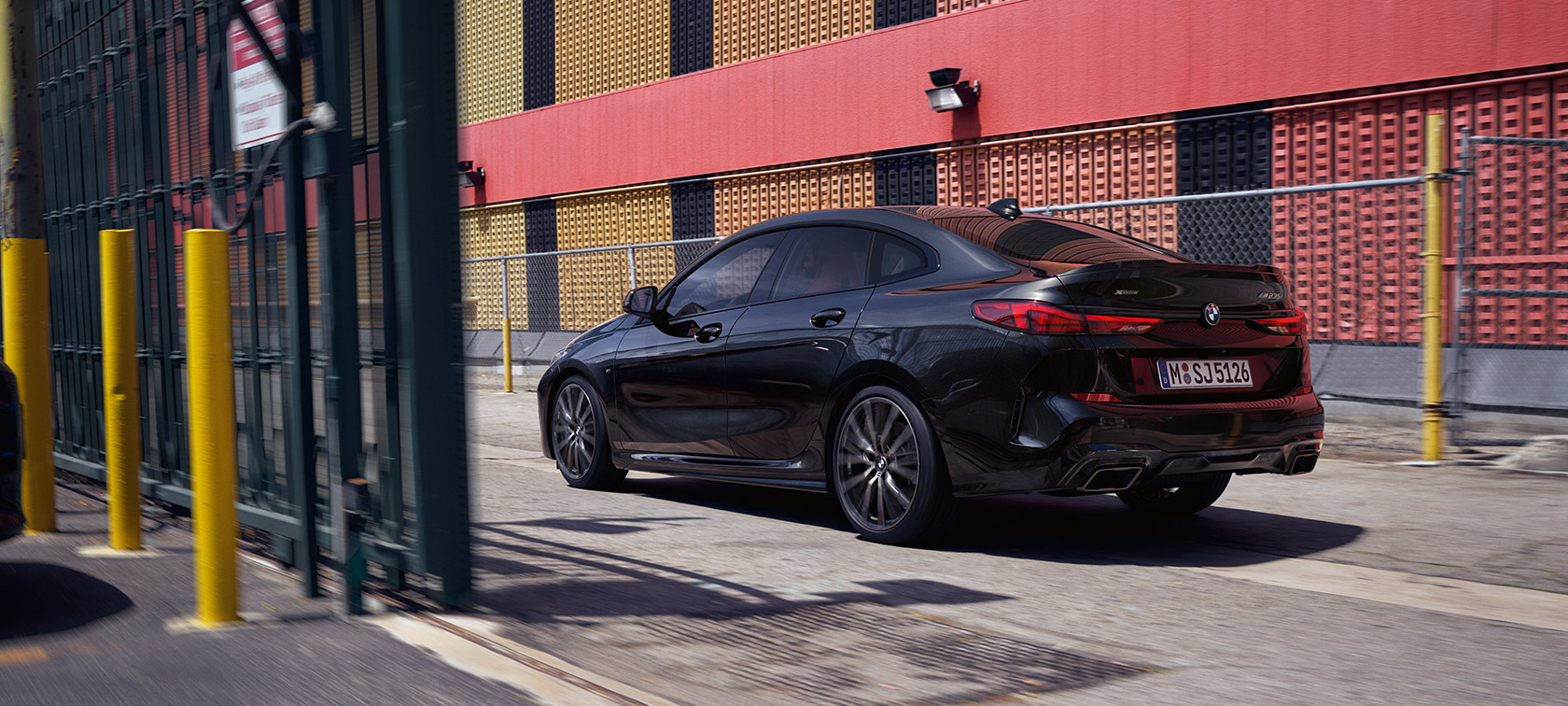BMW M235i xDrive Gran Coupé F44, kolmen neljäsosan näkymä liikkeellä olevan auton takaa BMW M235i xDrive Gran Coupé F44 metalliväri Black Sapphire, kolmen neljäsosan näkymä liikkeellä olevan auton takaa