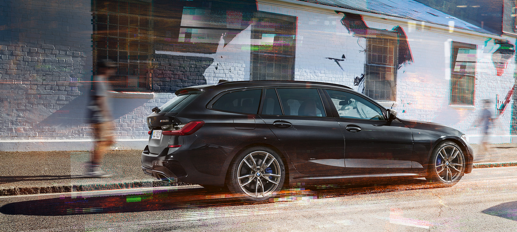 Näkymä BMW M340i xDrive Touringin (G21) sivulta BMW M340i xDrive Touring (G21) metalliväri Black Sapphire näkymä sivulta kadulla