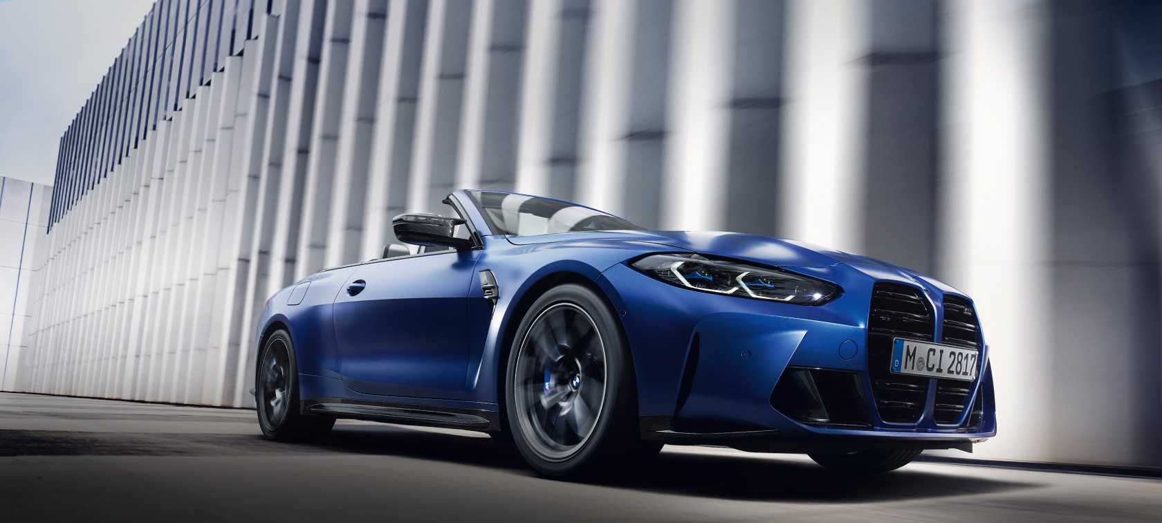 BMW M4 Competition Cabrio, jossa M xDrive G83 2021 BMW Individual Frozen Portimao Blue metalliväri sivunäkymä seisova auto sammakkoperspektiivi