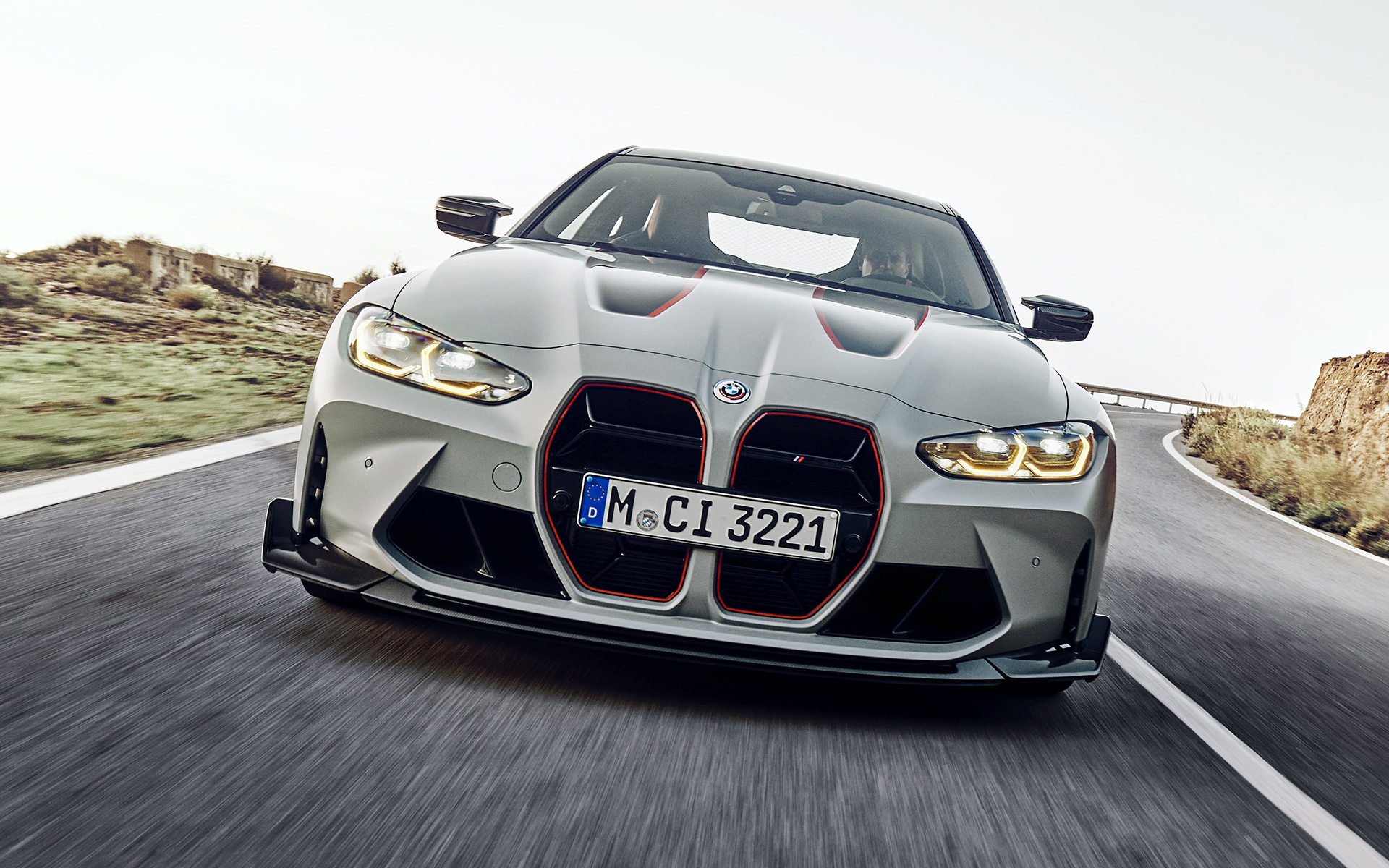 Mustat jäähdyttimen säleikön rivat, joissa punainen korostuskalvo, BMW M4 CSL G82 BMW M4 CSL G82 BMW Individual -erikoismetalliväri Frozen Brooklyn Grey, mustat jäähdyttimen säleikön rivat, joissa punainen korostuskalvo, näkymä kadulla ajavan auton keulasta