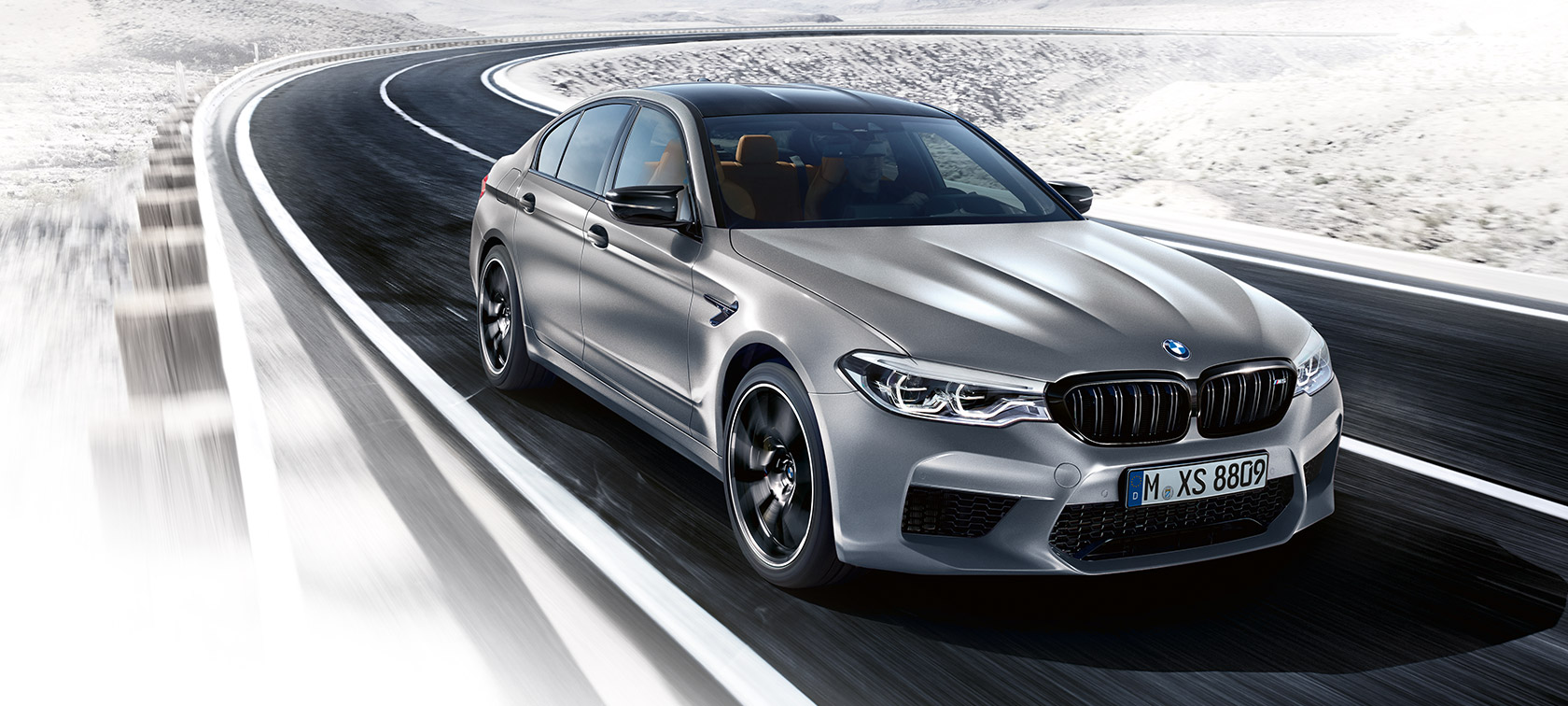 Muotoilun kohokohdat. BMW M5 Competition, kolme neljäsosan näkymä etuosasta auton ollessa liikkeellä.