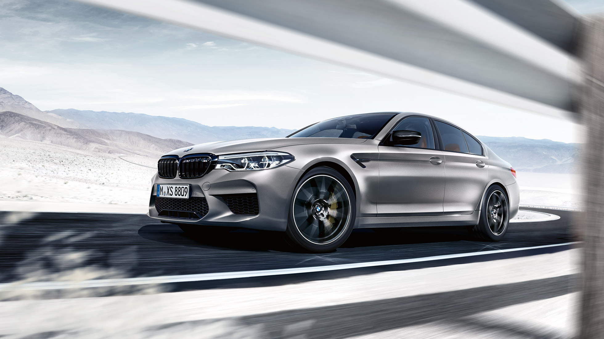 M xDrive. BMW M5 Competition, kolme neljäsosan näkymä etuosasta ajon aikana.