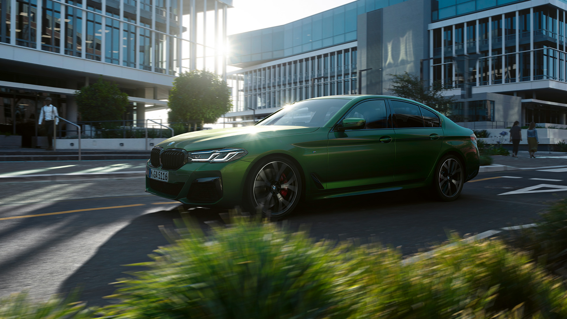 BMW M550i xDrive Sedan G30 LCI Facelift 2020 sivunäkymä ajavasta autosta BMW M550i xDrive Sedan G30 LCI Facelift 2020 BMW Individual metalliväri Verde Ermes sivunäkymä kaupungissa ajavasta autosta