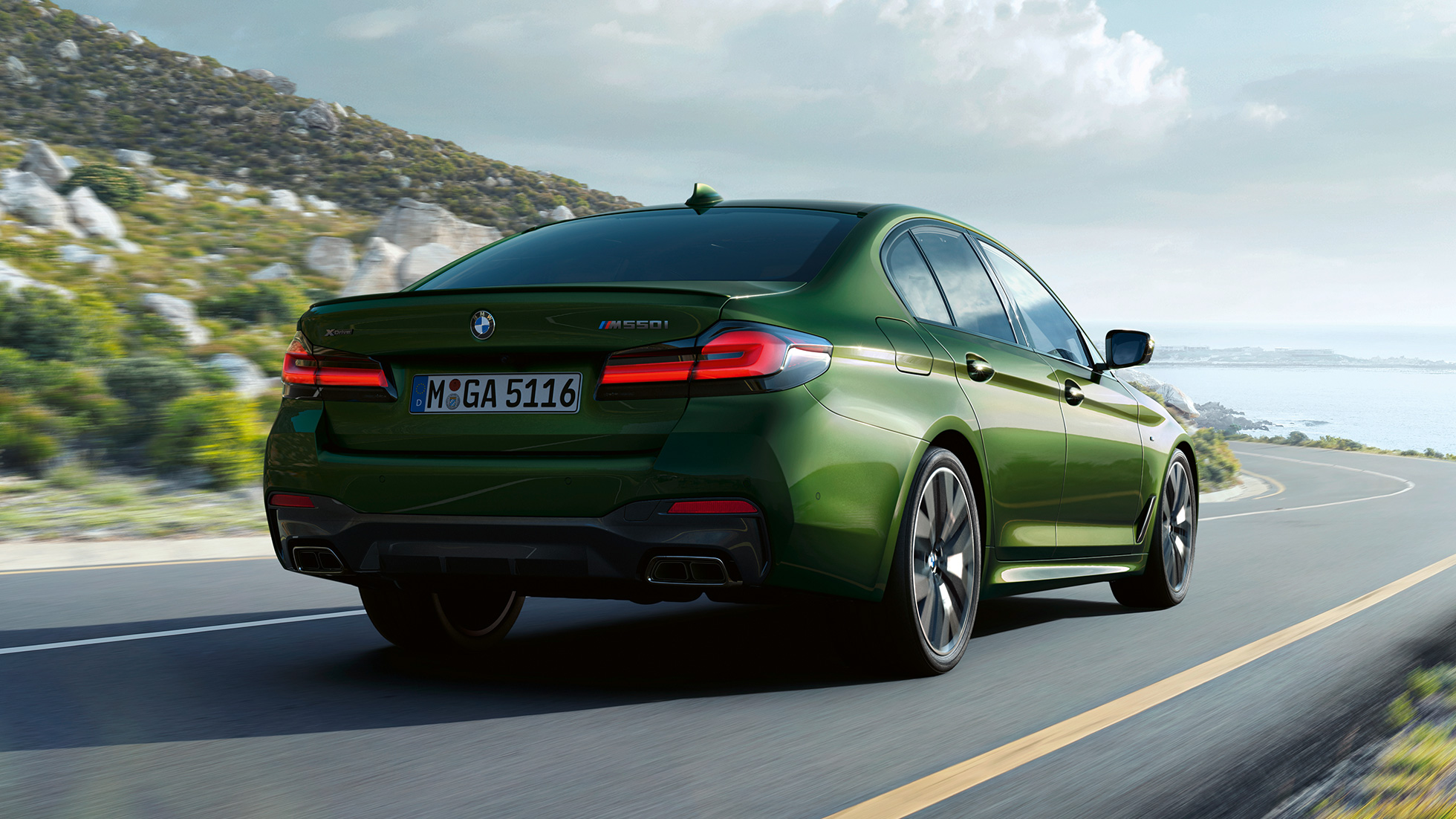BMW M550i xDrive Sedan G30 LCI Facelift 2020 näkymä perästä BMW M550i xDrive Sedan G30 LCI Facelift 2020 BMW Individual metalliväri Verde Ermes näkymä maantiellä ajavan auton perästä