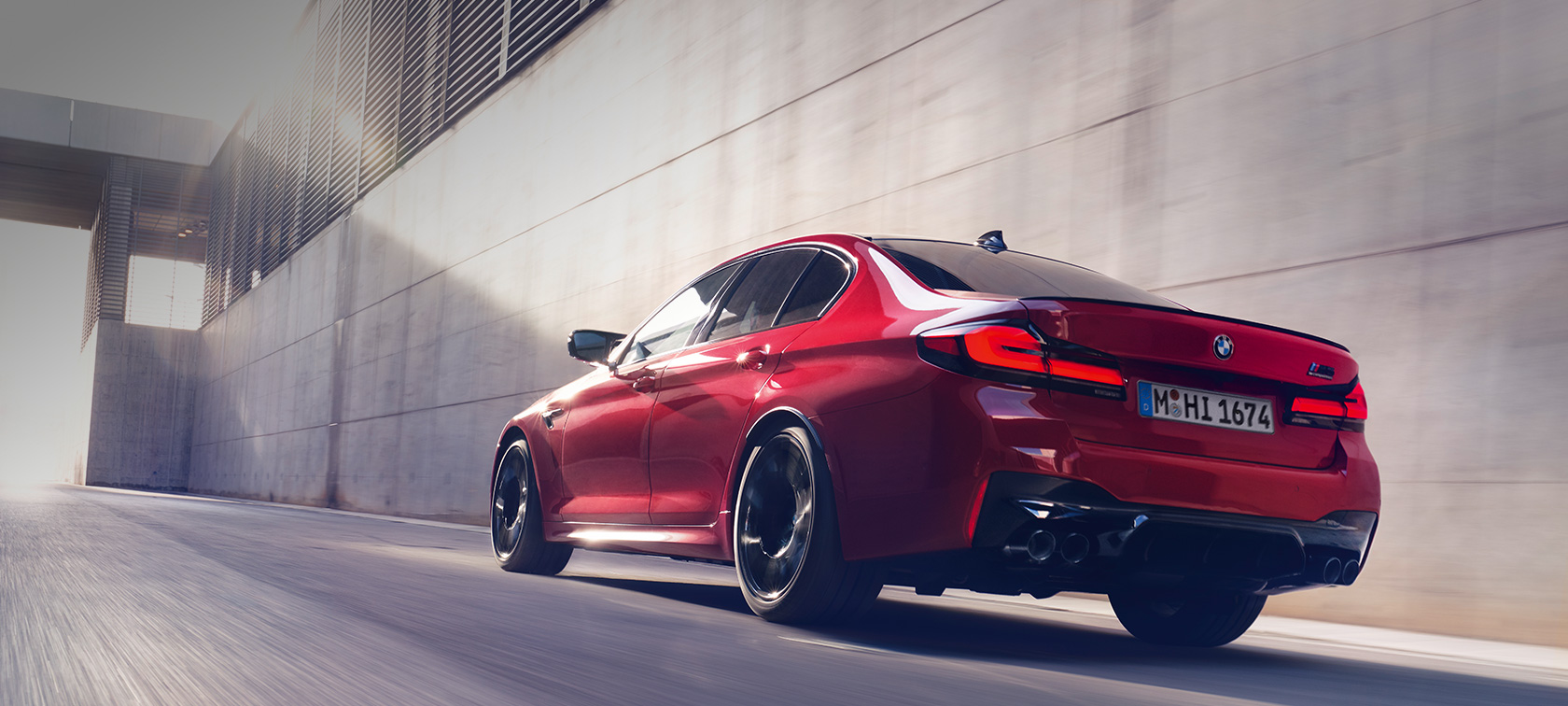 BMW M5 Competition F90 LCI Facelift 2020 kolmen neljäsosan näkymä ajavan auton perästä BMW M5 Competition F90 LCI Facelift 2020 BMW Individual Imola Red kolmen neljäsosan näkymä perästä auton ajaessa