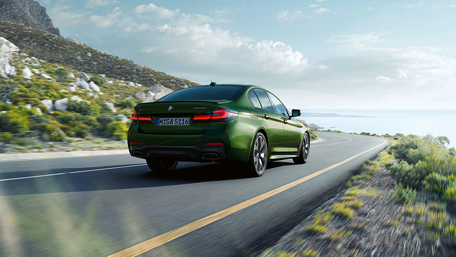 BMW M550i xDrive Sedan G30 LCI Facelift 2020 BMW Individual metalliväri Verde Ermes kolmen neljäsosan näkymä ajavan auton perästä