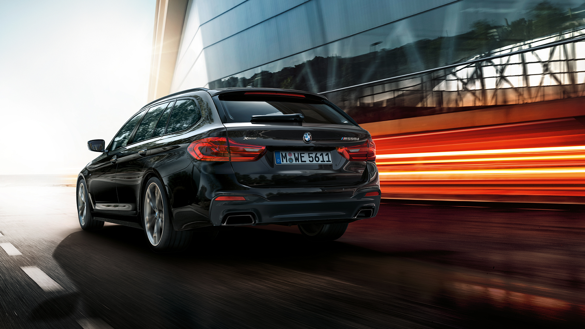 Kolmen neljäsosan näkymä BMW M550d xDrive Touringin takaosasta BMW M550d xDrive Touring G31, metalliväri Azurite Black, kolmen neljäsosan näkymä takaosasta