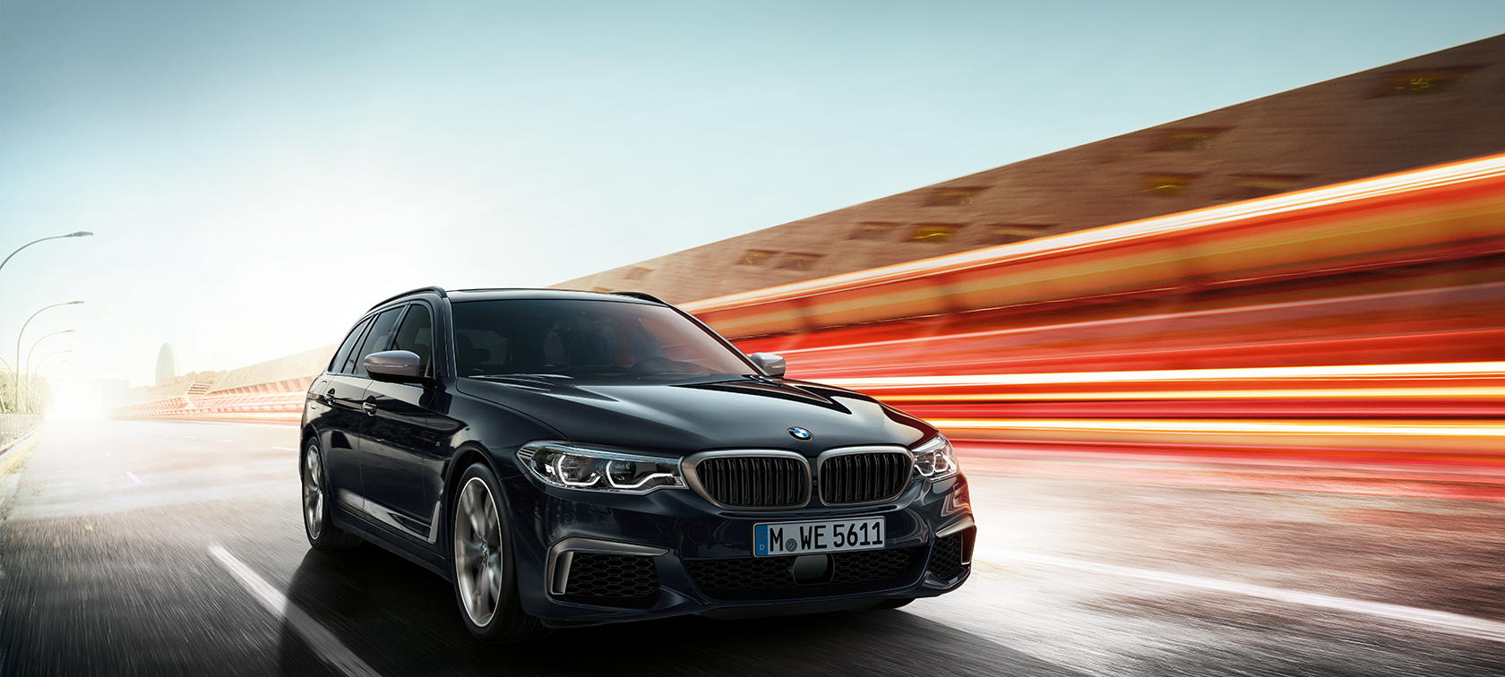 BMW M550d xDrive Touring, kolmen neljäsosan näkymä sivulta BMW M550d xDrive Touring uusi G31 metalliväri Azurite Black, kolmen neljäsosan näkymä etuosasta