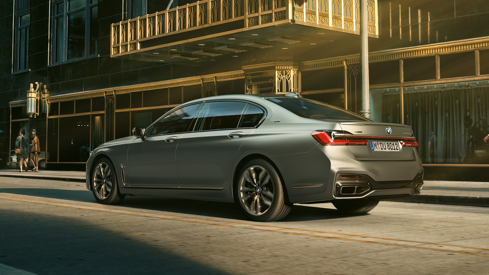 BMW M760Li xDrive Sedan ja V12-moottori BMW M760Li xDrive Sedan, sivunäkymä perästä pilvenpiirtäjien edessä kaupunkimaisemassa