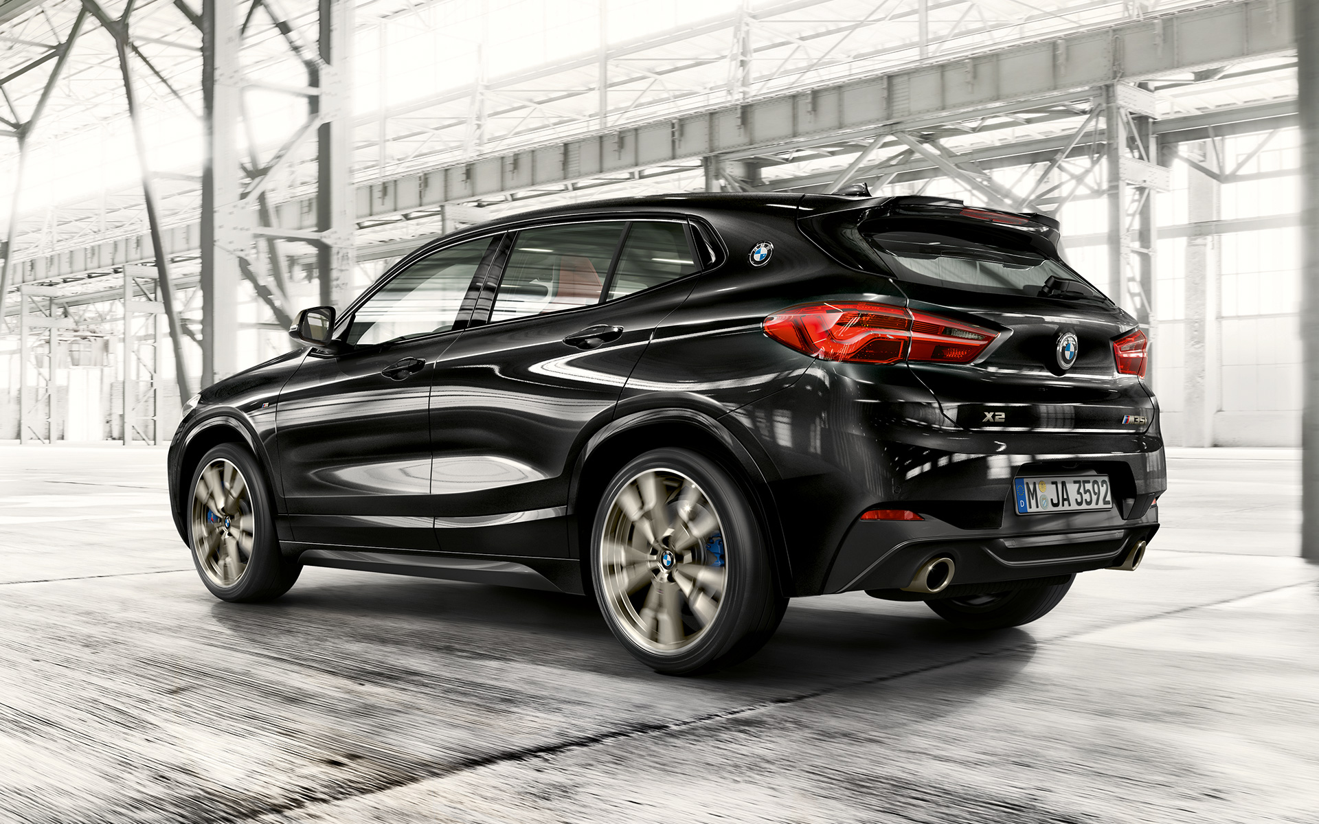 M takaspoileri, BMW X2 M35i (F39) metalliväri Black Sapphire, kolmen neljäsosan näkymä liikkeellä olevan auton takaa