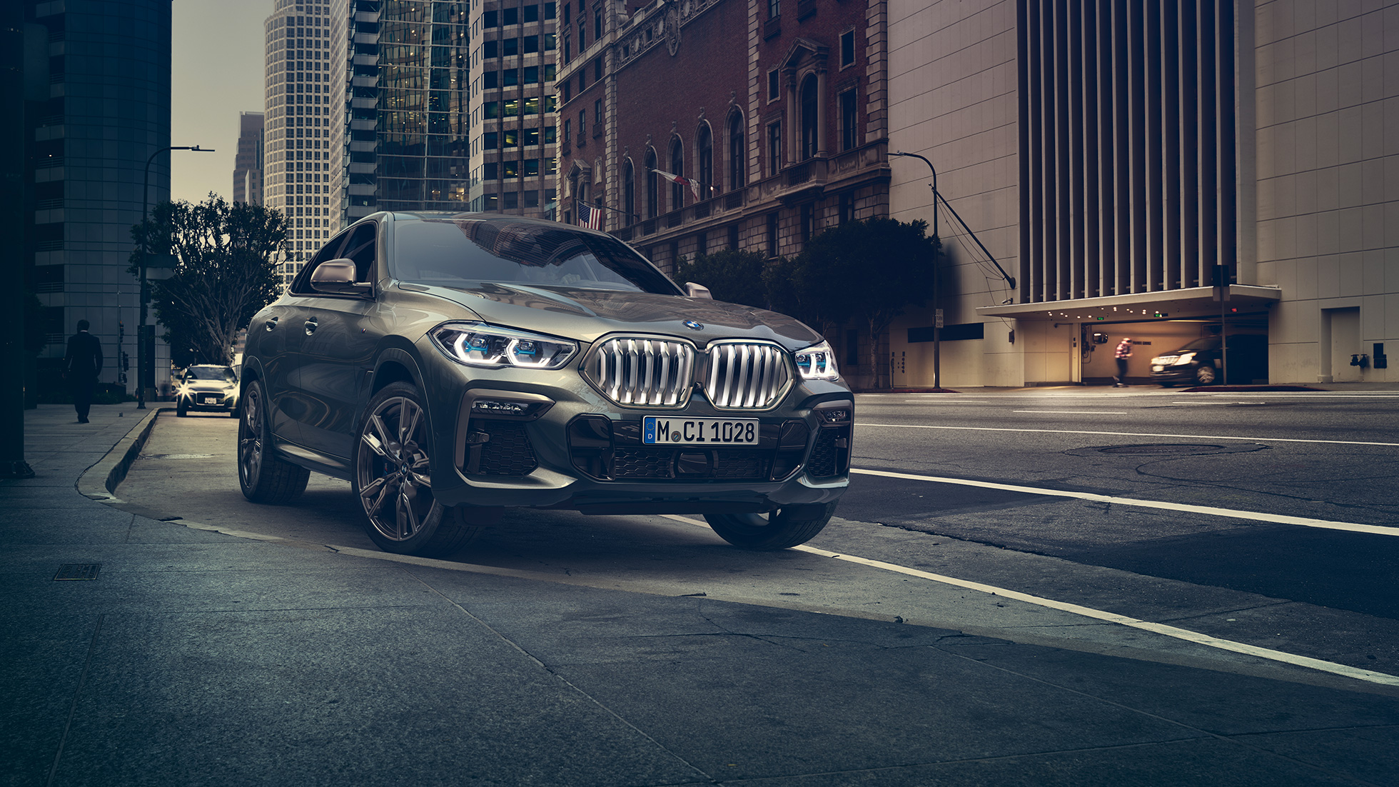 BMW X6 M50i pysähtyneenä BMW X6 M50i, 3/4-näkymä edestä auton ollessa pysähtyneenä kaupunkinäkymän edessä