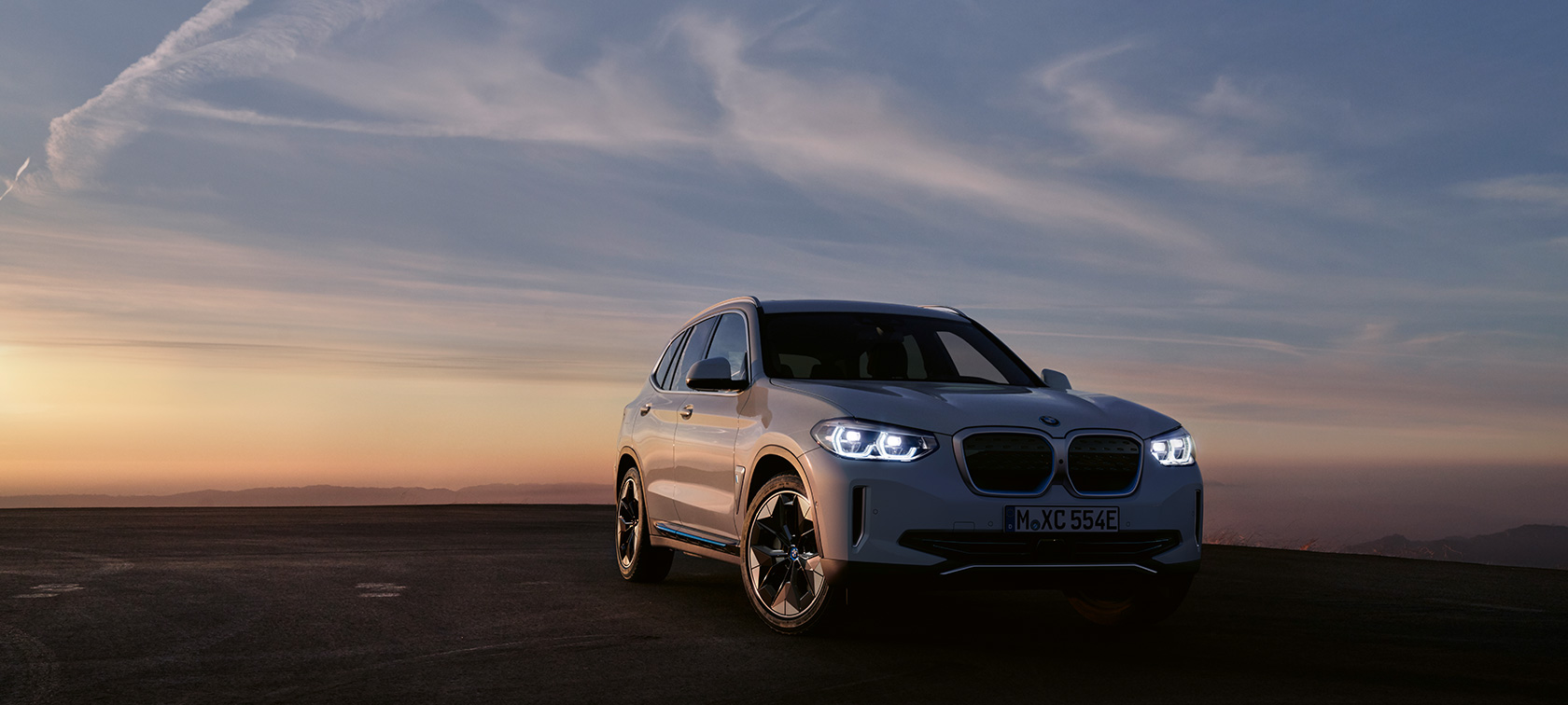 BMW iX3 G08 2020, kolmen neljäsosan näkymä keulasta BMW iX3 G08 2020, kolmen neljäsosan näkymä pysähtyneen auton keulasta iltatunnelmassa