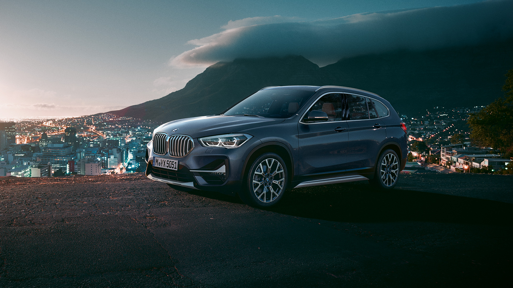 BMW X1, 3/4-sivunäkymä. BMW X1, 3/4-sivunäkymä auton ollessa pysähtyneenä kaupunkinäkymän edessä.