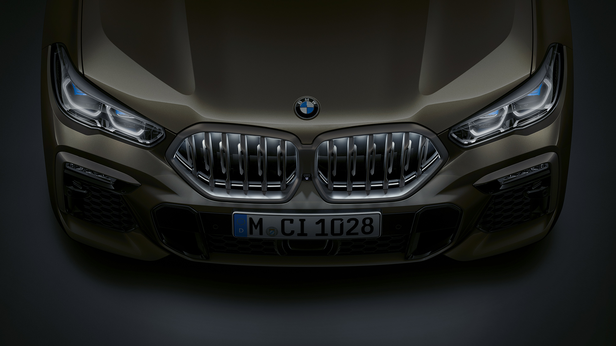 BMW X6, keula. Lintuperspektiivistä otettu lähikuva BMW X6:n keulassa olevasta BMW:n Iconic Glow -jäähdyttimensäleiköstä.