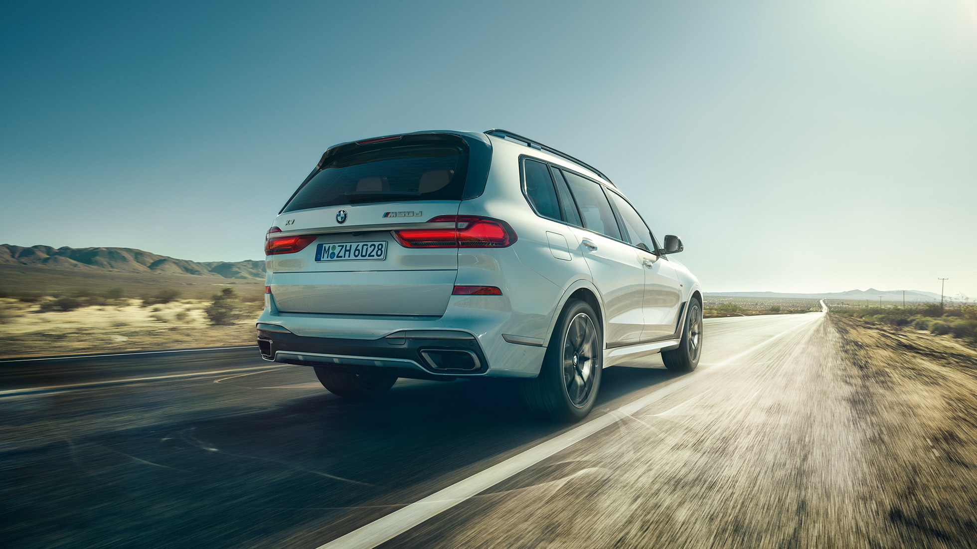 BMW X7 M50d, takaapäin BMW X7 M50d: liikkuva, valkoinen BMW X7 takaapäin