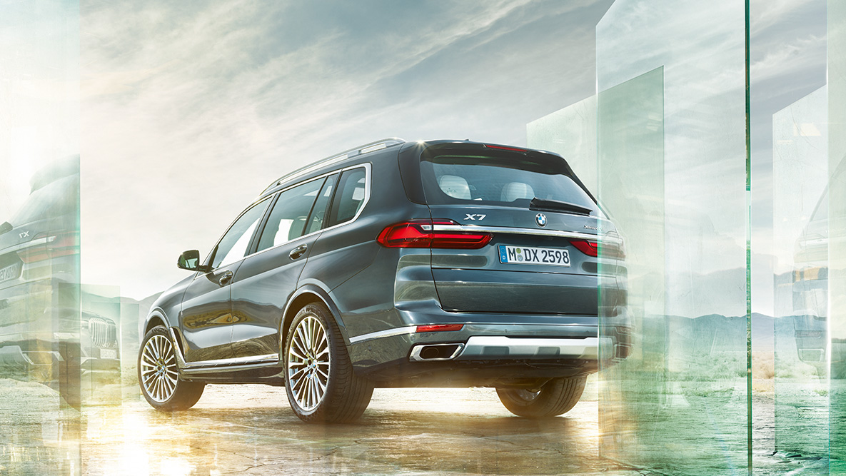 BMW X7:n ajomukavuus ja ajodynamiikka Kolmeneljäsosakuvassa BMW X7 takaapäin abstraktia taustaa vasten