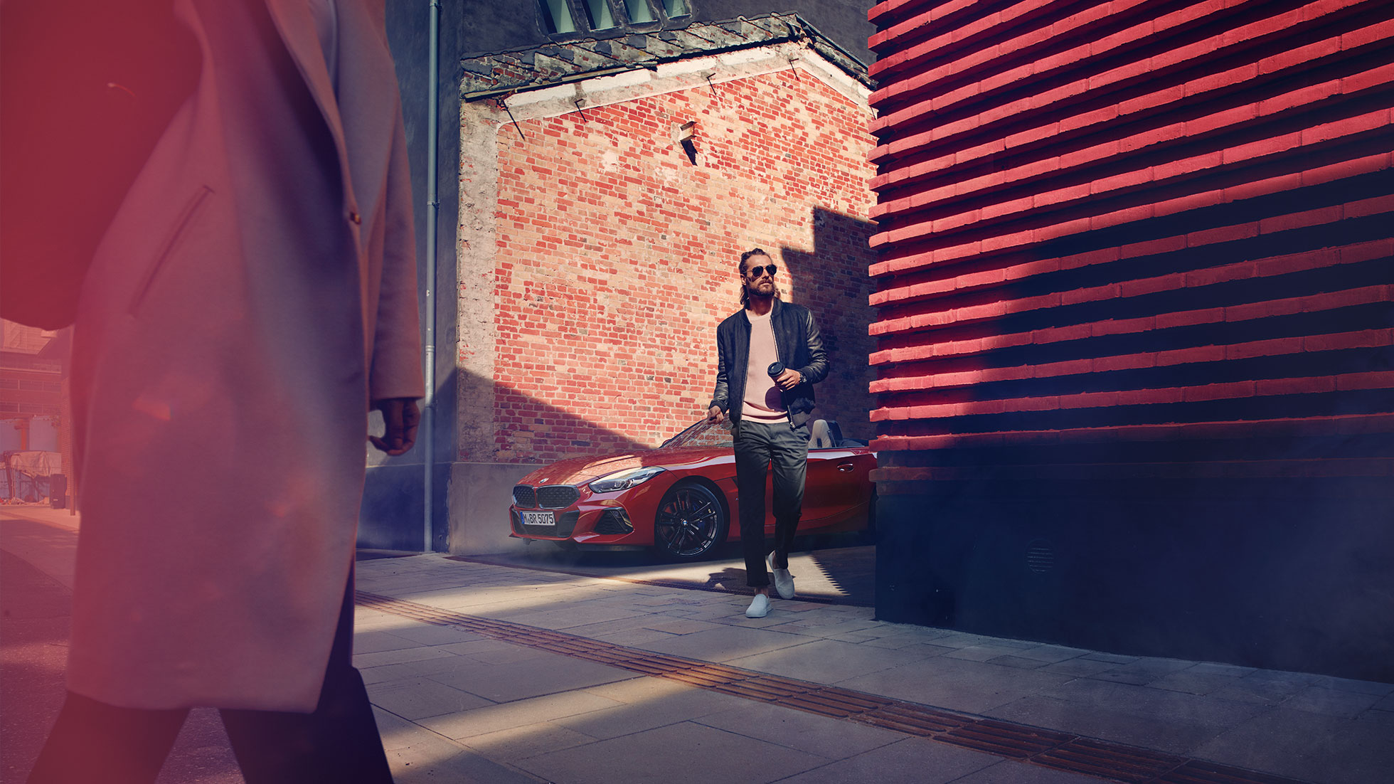 BMW Z4 Roadster sivukadulla Mies sivukadulla BMW Z4 Roadsterin edessä
