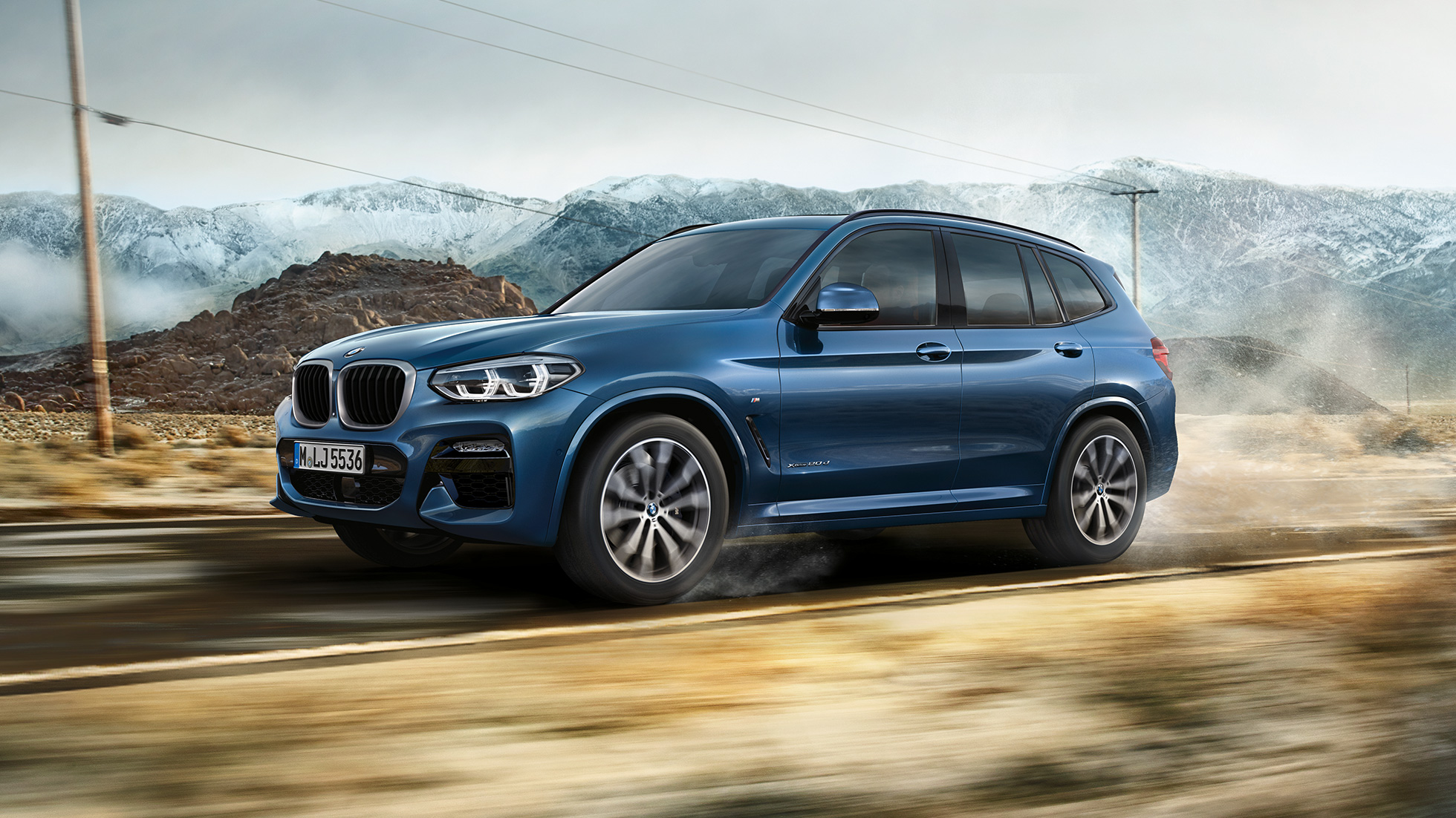 BMW X3 M40i 2020 G01, sivukuva liikkeellä olevasta autosta BMW X3 M40i 2020 G01, sivukuva vuorijonon edustalla ajavasta autosta