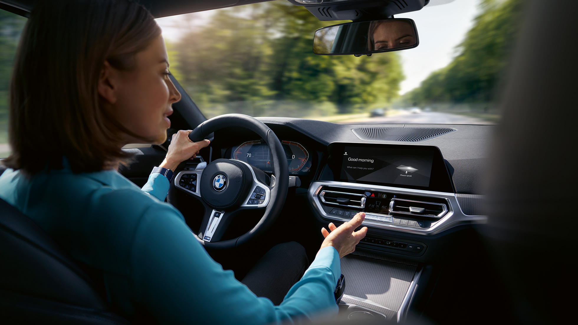 Nainen käyttää Intelligent Personal Assistantia BMW-autossaan Nainen käyttää BMW ConnectedDriven Intelligent Personal Assistantia BMW-autossaan
