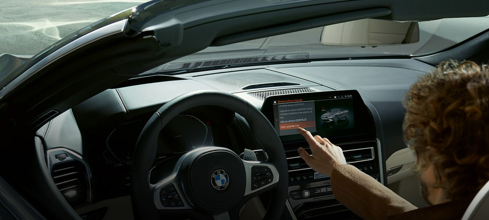 BMW Remote Software Upgrade Mies istuu BMW-autossa ja käynnistää BMW Remote Software Upgraden