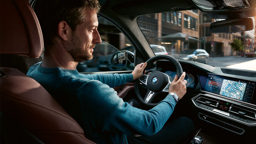 Pysäköintipaikka-avustin Mies käyttää BMW:n näytössä näytettävää pysäköintipaikka-avustinta