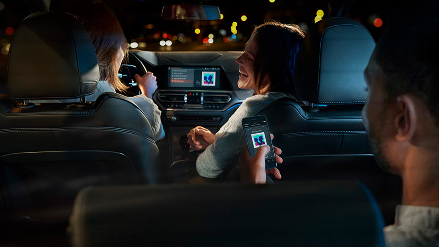 Connected Command Connected Command: kolme henkilöä istuu BMW:n kyydissä ja kuuntelee musiikkia matkan aikana