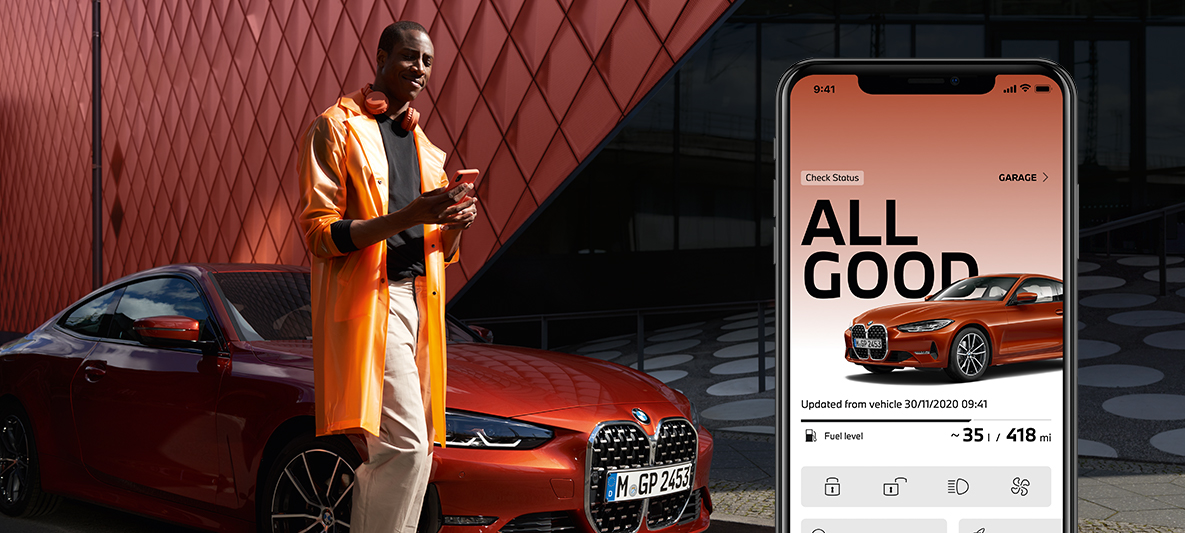 My BMW -sovellus, auton tilan tarkistus, mies älypuhelimen kanssa BMW 2-sarjan Coupén edessä My BMW -sovellus, auton tilan tarkistus, mies älypuhelimen kanssa BMW 2-sarjan Coupén edessä
