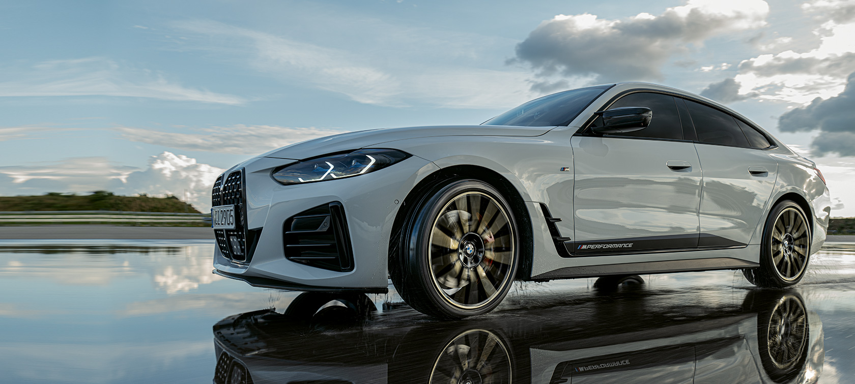 BMW 4-sarjan Gran Coupé (G26), jossa on M Performance -osia, liikkeellä märällä tiellä BMW 4-sarjan Gran Coupé (G26), jossa on M Performance -osia, liikkeellä märällä tiellä