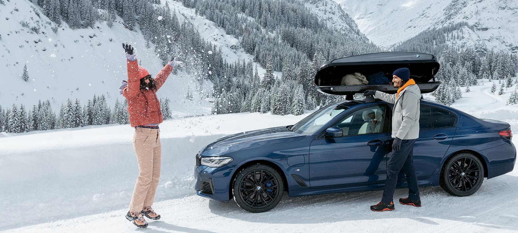 Alkuperäiset BMW lisävarusteet ja BMW Service syksyyn ja talveen Nainen ja mies nauravat rengaspulkassa lumessa