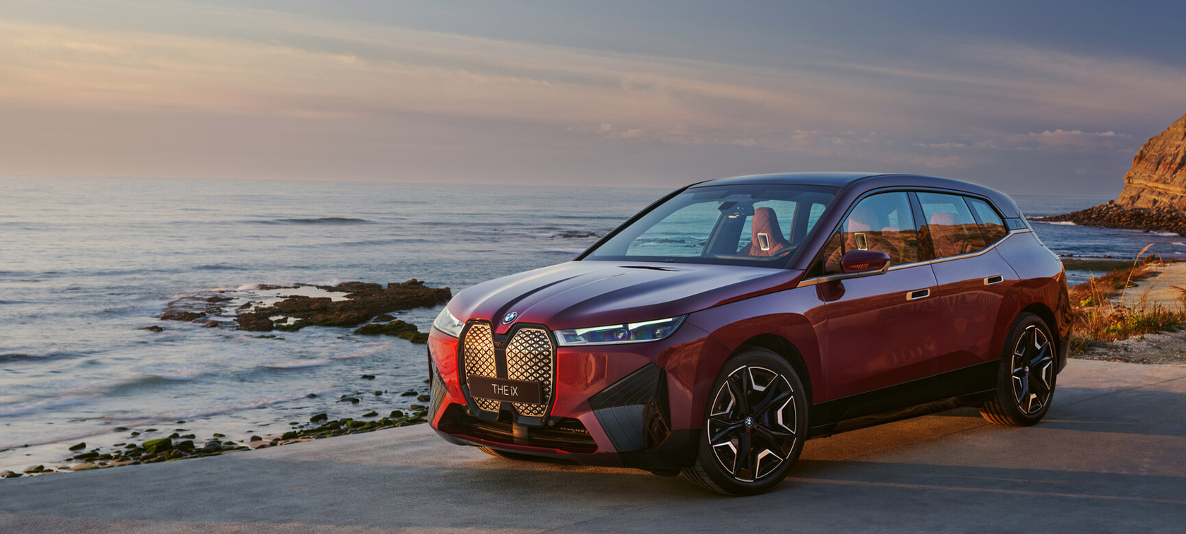 BMW iX i20 2021, sähköinen SUV, BMW iX xDrive50, Aventurine Red, näkymä rannikolla
