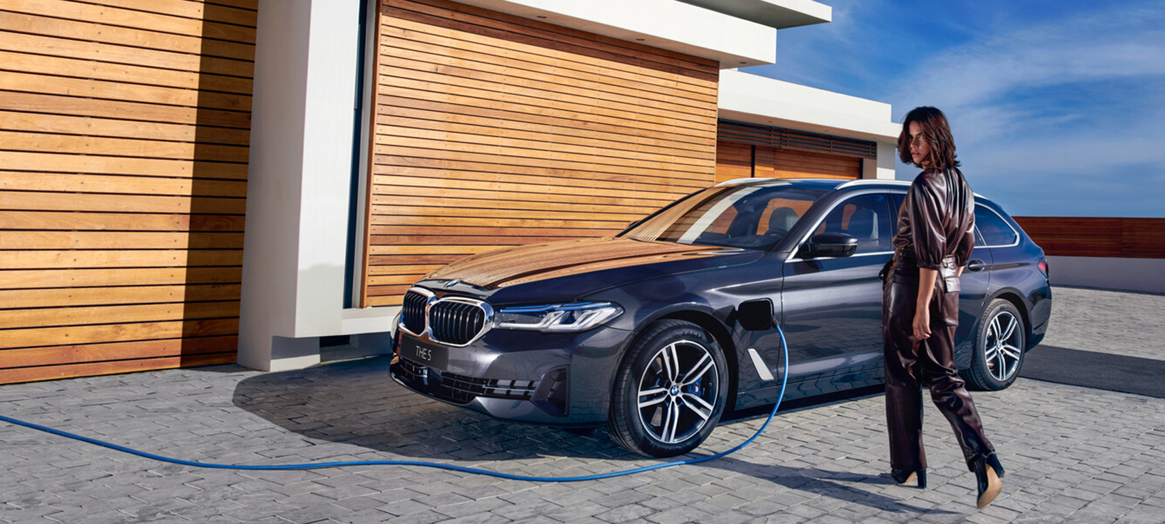 BMW 5-sarjan Touring G31 Facelift 2020 Sophisto Grey, 7/8-näkymä laitakaupungilla ajavan auton keulasta